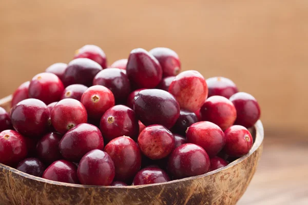 Cranberries. Cranberries in wooden bowl on wooden background. — Stock Photo, Image