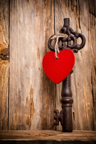 Schlüssel. alter Vintage-Schlüssel mit Herz auf Holzgrund. — Stockfoto