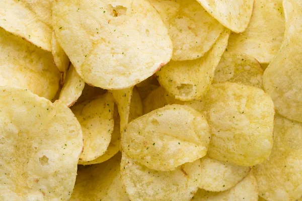 Close-up van aardappel chips op bovenaanzicht achtergrond. — Stockfoto