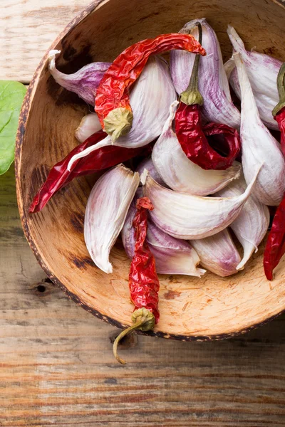 Bündel frisches Spinachl auf einem hölzernen Hintergrund. Knoblauchmischung in einer Schüssel. — Stockfoto