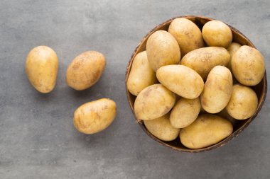 Kase, gri arka plan üzerinde yeni patates.