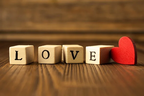Amor. Mensaje de amor escrito en bloques de madera. Corazón rojo . —  Fotos de Stock