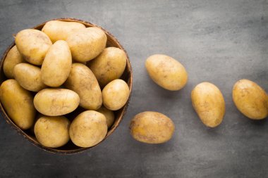 Kase, gri arka plan üzerinde yeni patates.