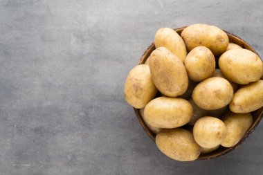Kase, gri arka plan üzerinde yeni patates.