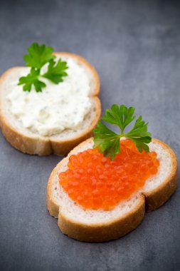 Ekmek taze krem peynir ve masada kırmızı havyar ile.