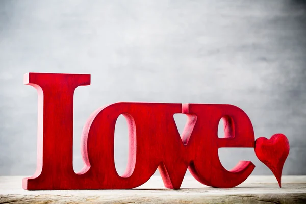 Láska. Poselství lásky s červenými dřevěnými písmeny. — Stock fotografie