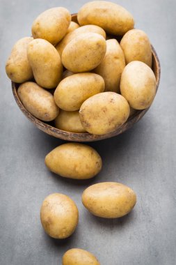 Kase, gri arka plan üzerinde yeni patates.