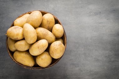 Kase, gri arka plan üzerinde yeni patates.