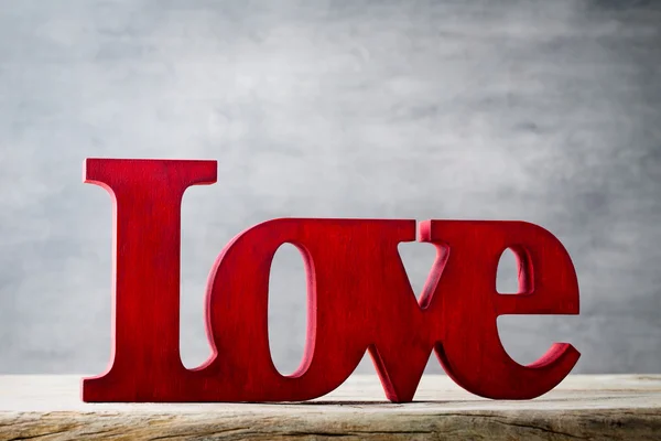 Com amor. Mensagem de amor com letras vermelhas de madeira . — Fotografia de Stock