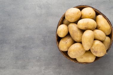 Kase, gri arka plan üzerinde yeni patates.