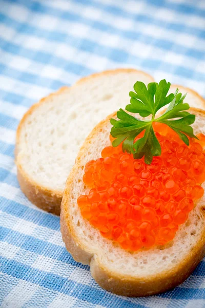 Ekmek taze krem peynir ve masada kırmızı havyar ile.