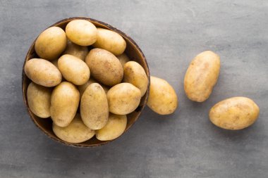 Kase, gri arka plan üzerinde yeni patates.