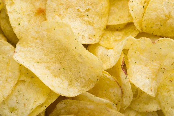 Close-up van aardappel chips op bovenaanzicht achtergrond. — Stockfoto