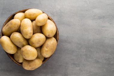 Kase, gri arka plan üzerinde yeni patates.