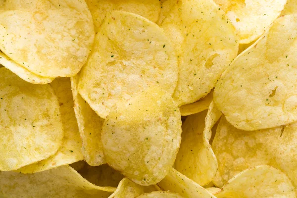 Close-up van aardappel chips op bovenaanzicht achtergrond. — Stockfoto