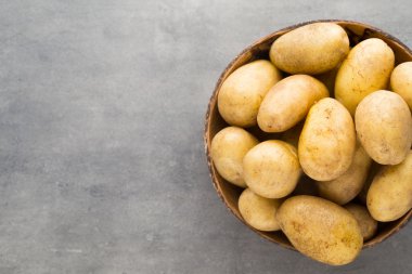 Kase, gri arka plan üzerinde yeni patates.