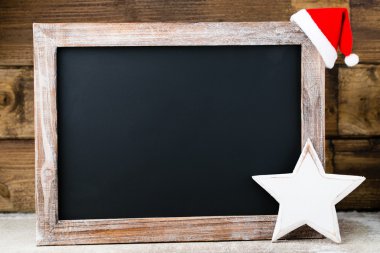 Noel dekorasyonu ile kara tahta. Noel Baba şapkası, yıldız, tahta 