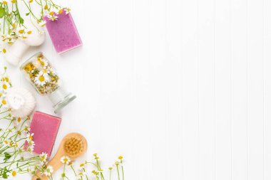 Doğal kozmetik ürünleri ve açık arkaplanda papatya çiçekleri ile kompozisyon aroması.