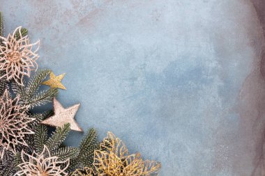 Noel kompozisyonu köknar ağacı dalları, mavi arka planda altın göğüs..