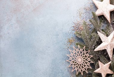 Noel kompozisyonu köknar ağacı dalları, mavi arka planda altın göğüs..