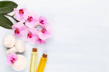 Spa aromaterapi arka planı, basit orkide çiçekleriyle süslenmiş çeşitli güzellik ürünleri..