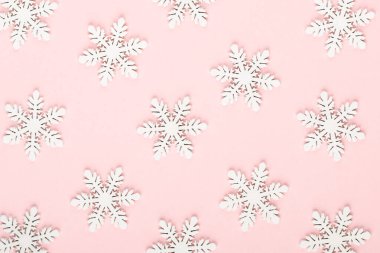 Noel arkaplanı. Pembe arka planda beyaz kar dekorasyonları.