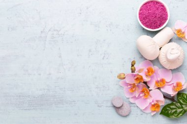 Spa aromaterapi arka planı, basit orkide çiçekleriyle süslenmiş çeşitli güzellik ürünleri..