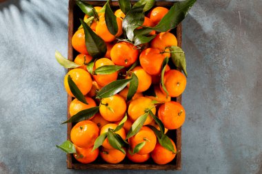 Tahta kutuda yaprakları olan taze mandalina portakalları..
