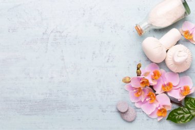Spa aromaterapi arka planı, basit orkide çiçekleriyle süslenmiş çeşitli güzellik ürünleri..