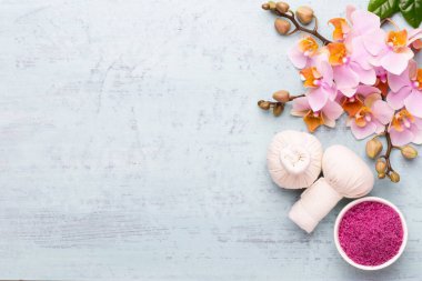 Spa aromaterapi arka planı, basit orkide çiçekleriyle süslenmiş çeşitli güzellik ürünleri..