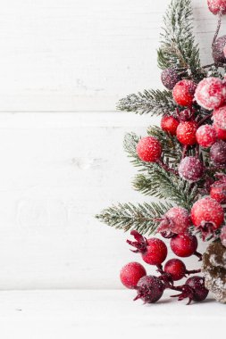 Kırmızı böğürtlenlerden, kürk ağacından ve konilerden Noel çelengi