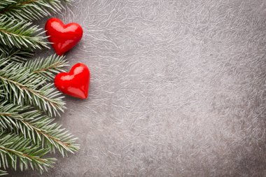 Gri arka planda Noel süslemeleri olan ladin dalı.