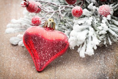 Ahşap arka planda köknar dallarıyla Noel süslemesi.