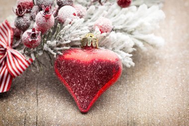 Ahşap arka planda köknar dallarıyla Noel süslemesi.