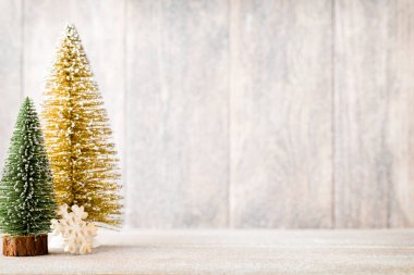 Ahşap bir arka planda altın ve yeşil Noel ağacı.