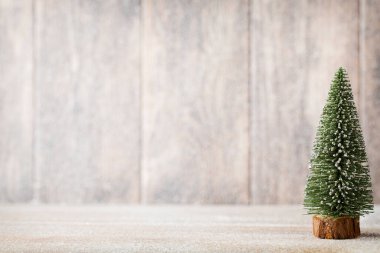 Ahşap bir arka planda altın ve yeşil Noel ağacı.