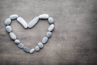Kalp kaplıca taşlarından, gri arka planda..