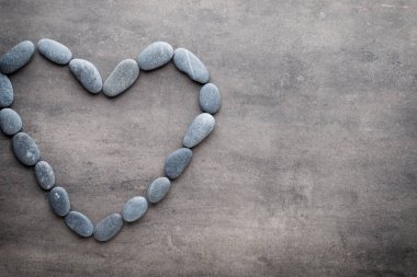 Kalp kaplıca taşlarından, gri arka planda..