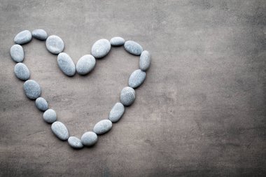 Kalp kaplıca taşlarından, gri arka planda..