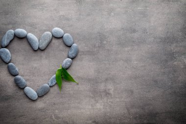 Kalp kaplıca taşlarından, gri arka planda..