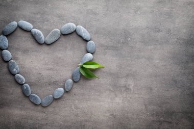 Kalp kaplıca taşlarından, gri arka planda..