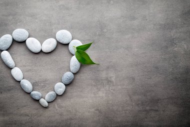 Kalp kaplıca taşlarından, gri arka planda..