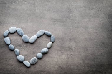 Kalp kaplıca taşlarından, gri arka planda..