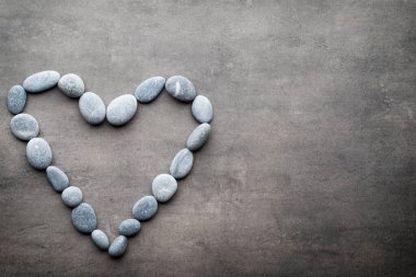 Kalp kaplıca taşlarından, gri arka planda..