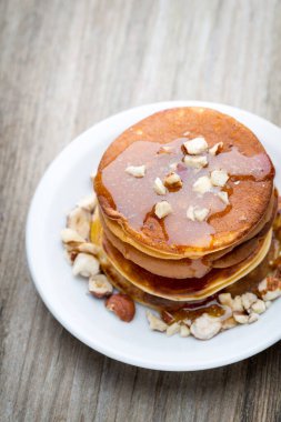 Ahşap arka planda ballı ev yapımı krep yığını.