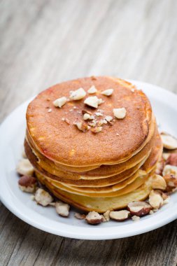 Ahşap arka planda ballı ev yapımı krep yığını.