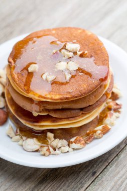 Ahşap arka planda ballı ev yapımı krep yığını.