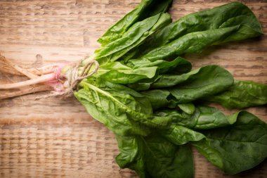 Ahşap arka planda kökleri olan ıspanak..