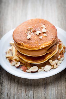 Ahşap arka planda ballı ev yapımı krep yığını.