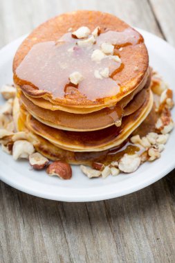 Ahşap arka planda ballı ev yapımı krep yığını.